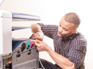 black man fixing copier
