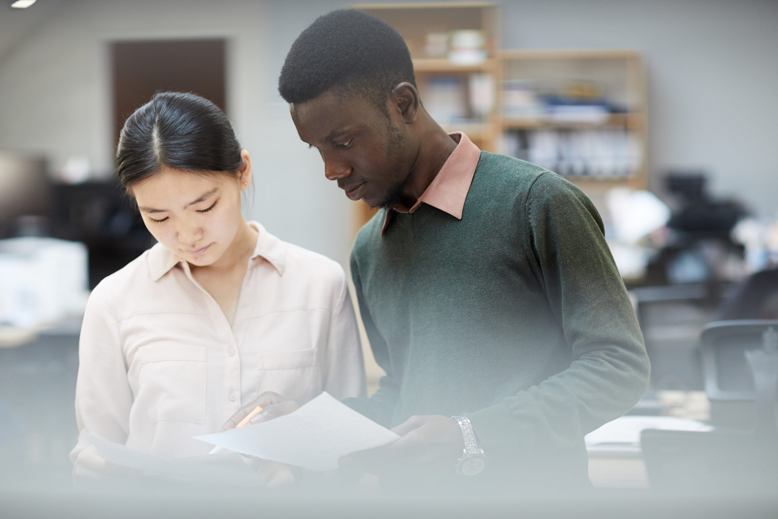 black man and asian woman in office