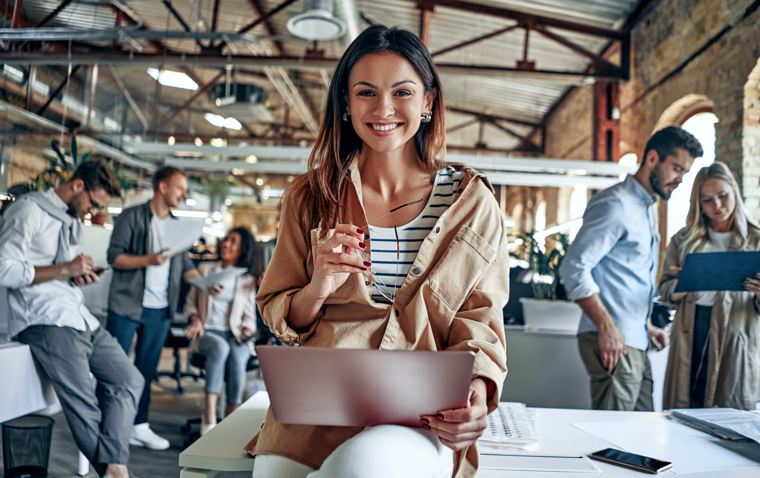 Woman in office holding laptop