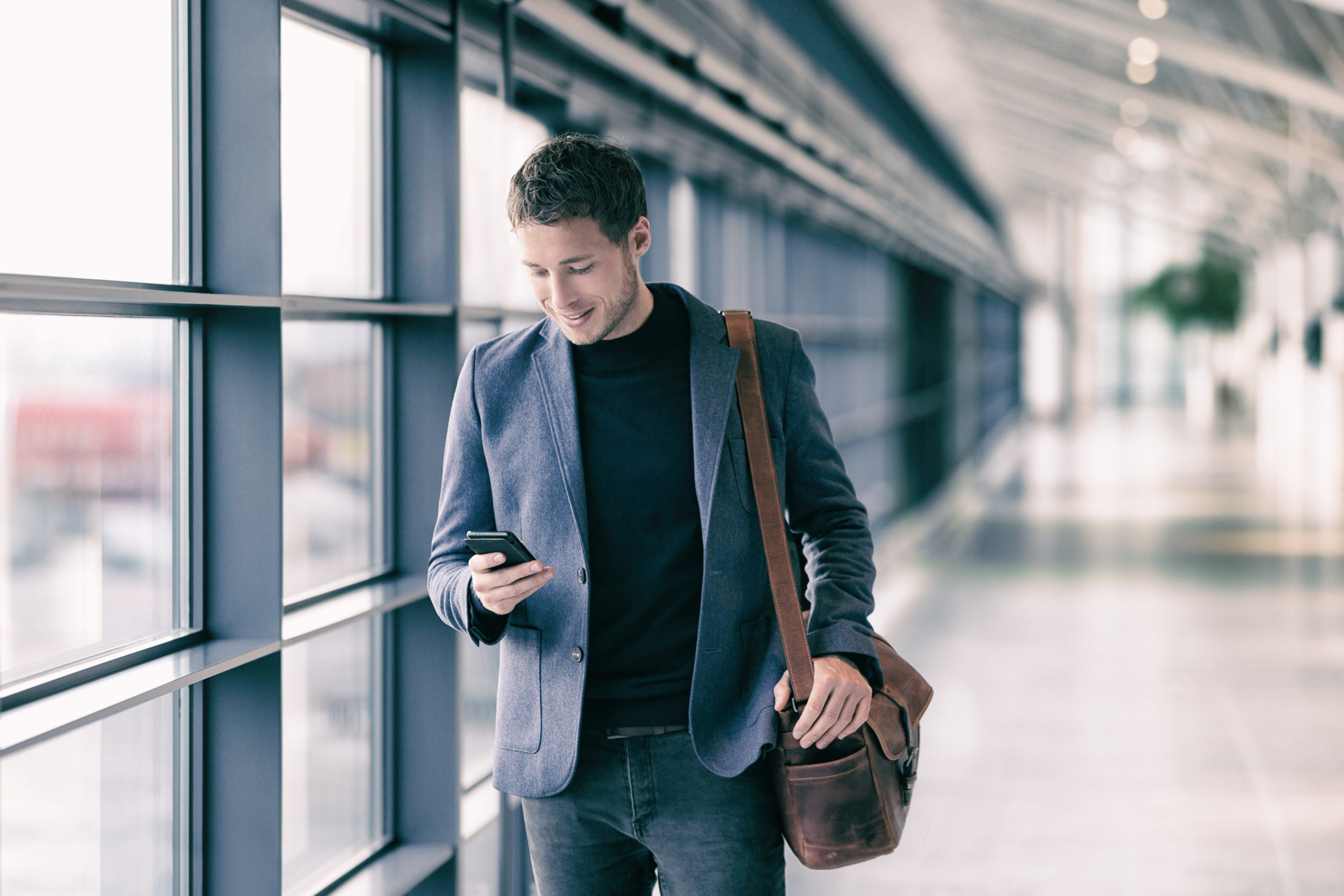 Photo of business man on the go in the airport on phone