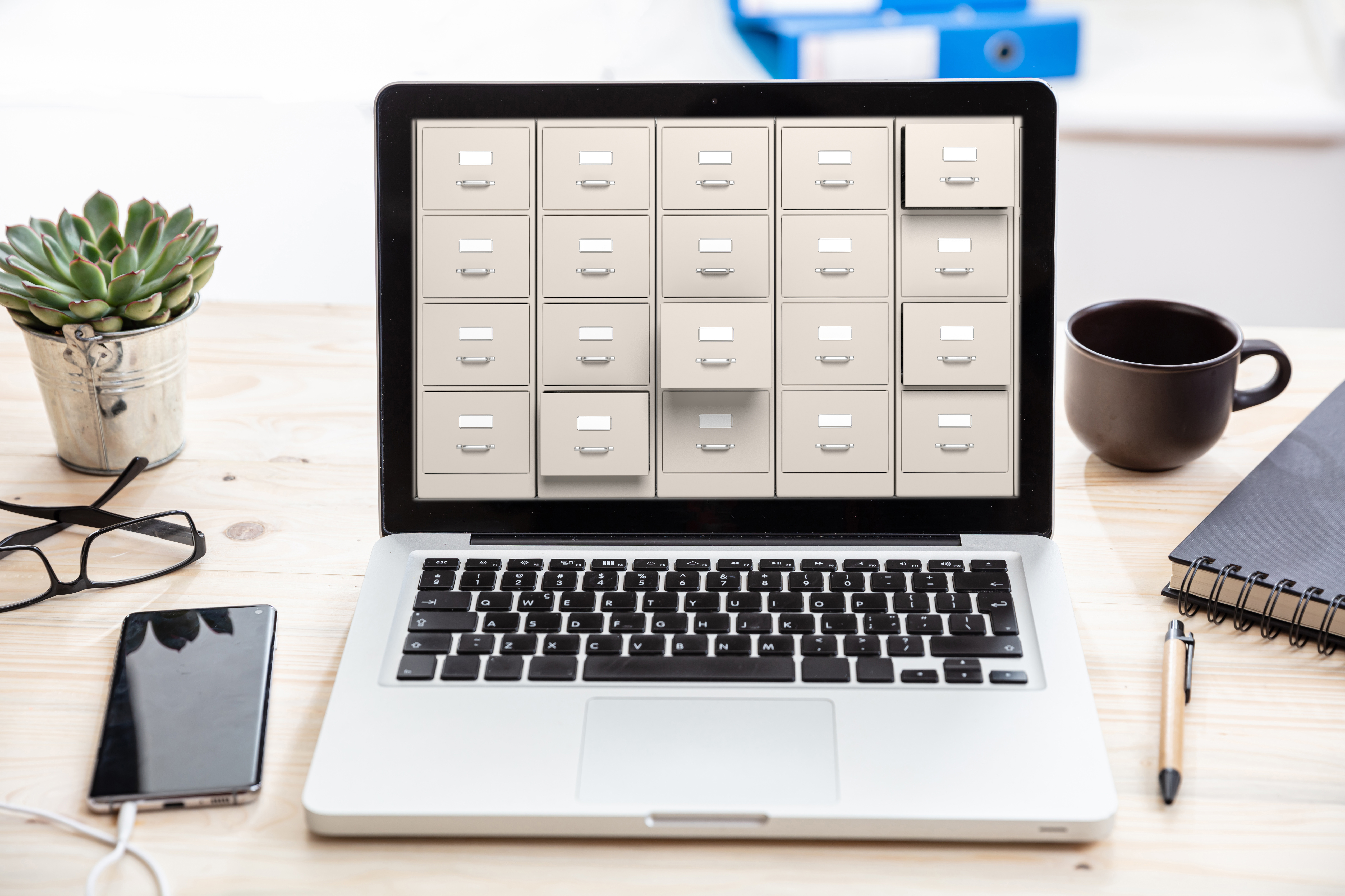 Photo of laptop open with digital filing cabinets on the screen