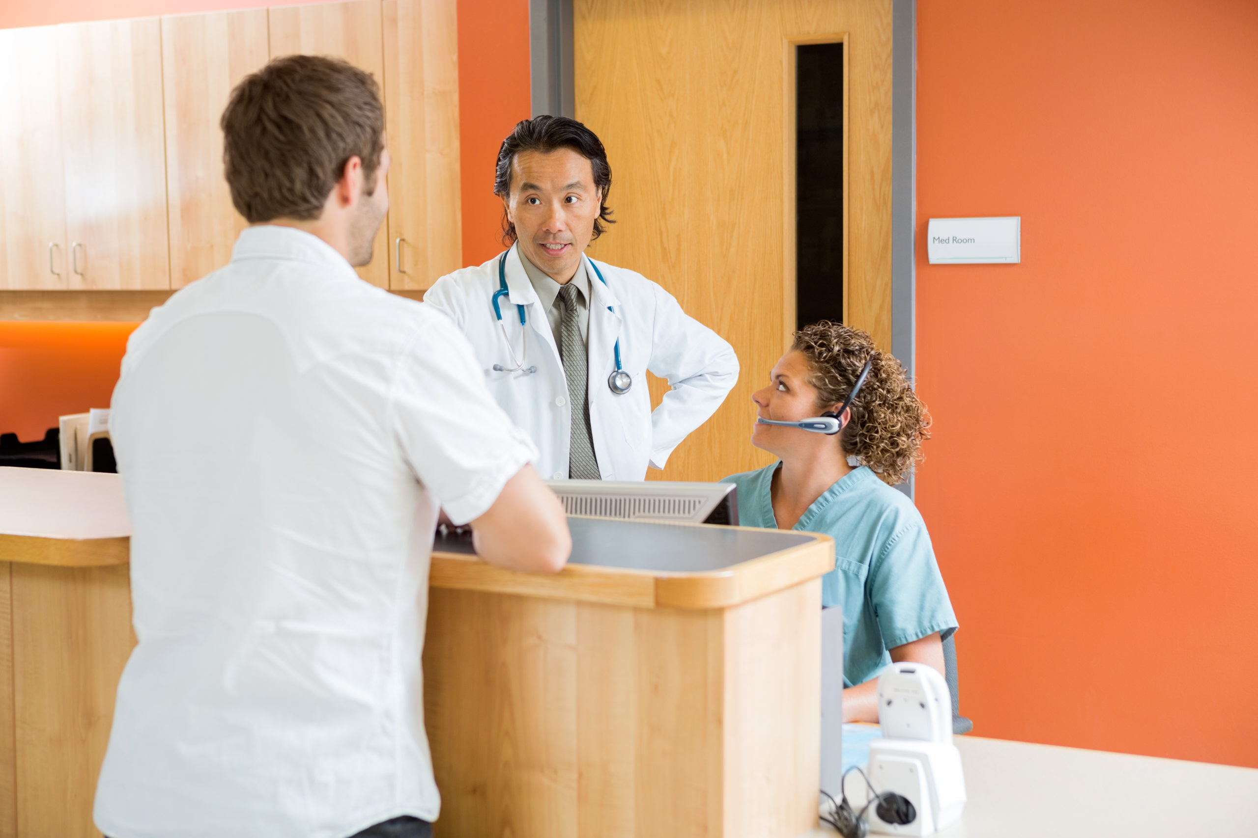 photo of nurse and doctor at desk talking to patient