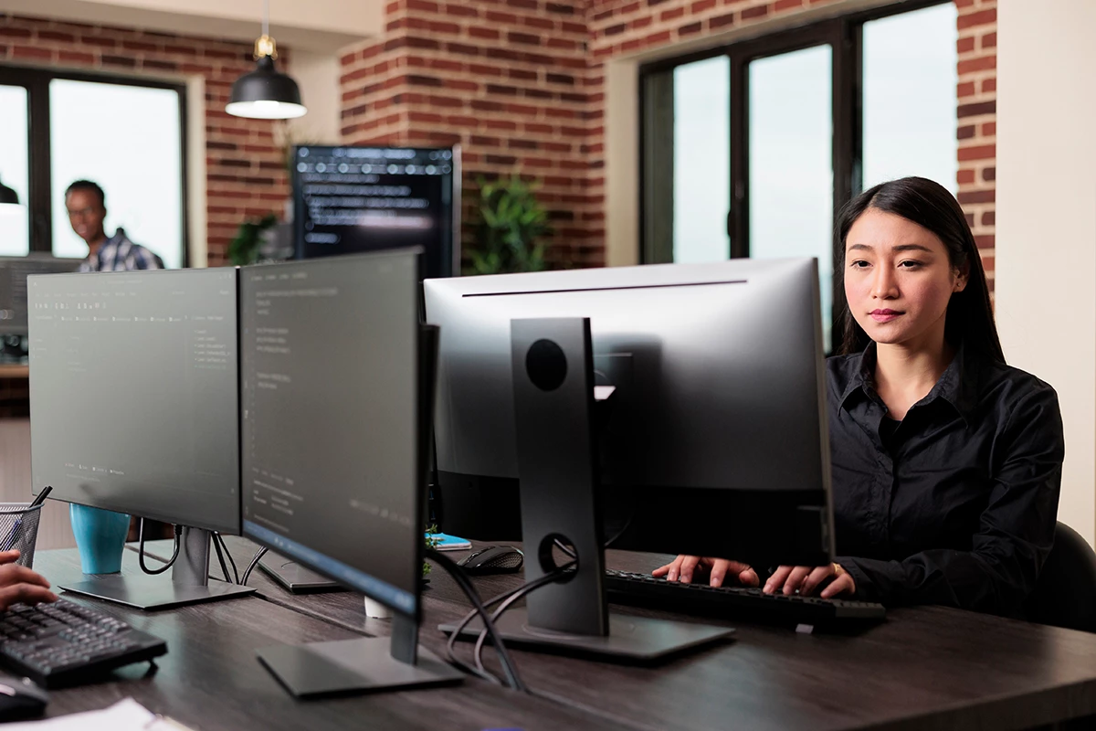 Managed IT Service provider working at workstation with computer monitors
