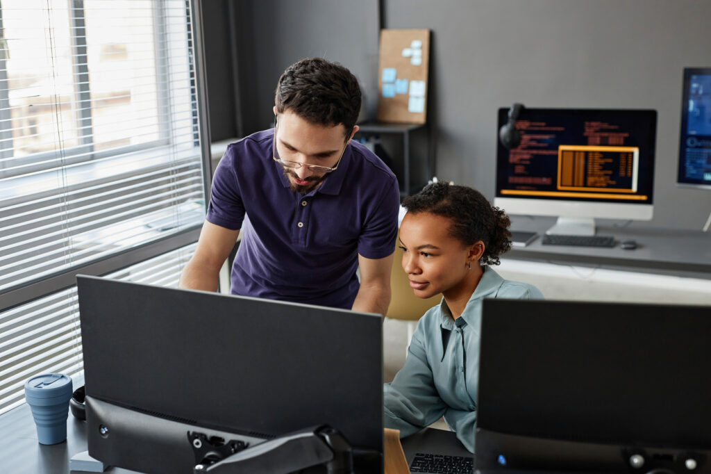 IT professionals discussing over computer in office