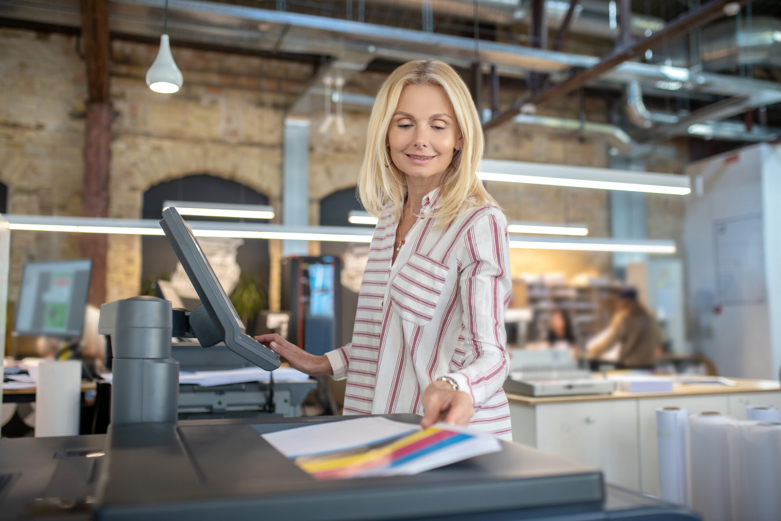Blonde woman choosing paper printing settings, selecting colors on printer