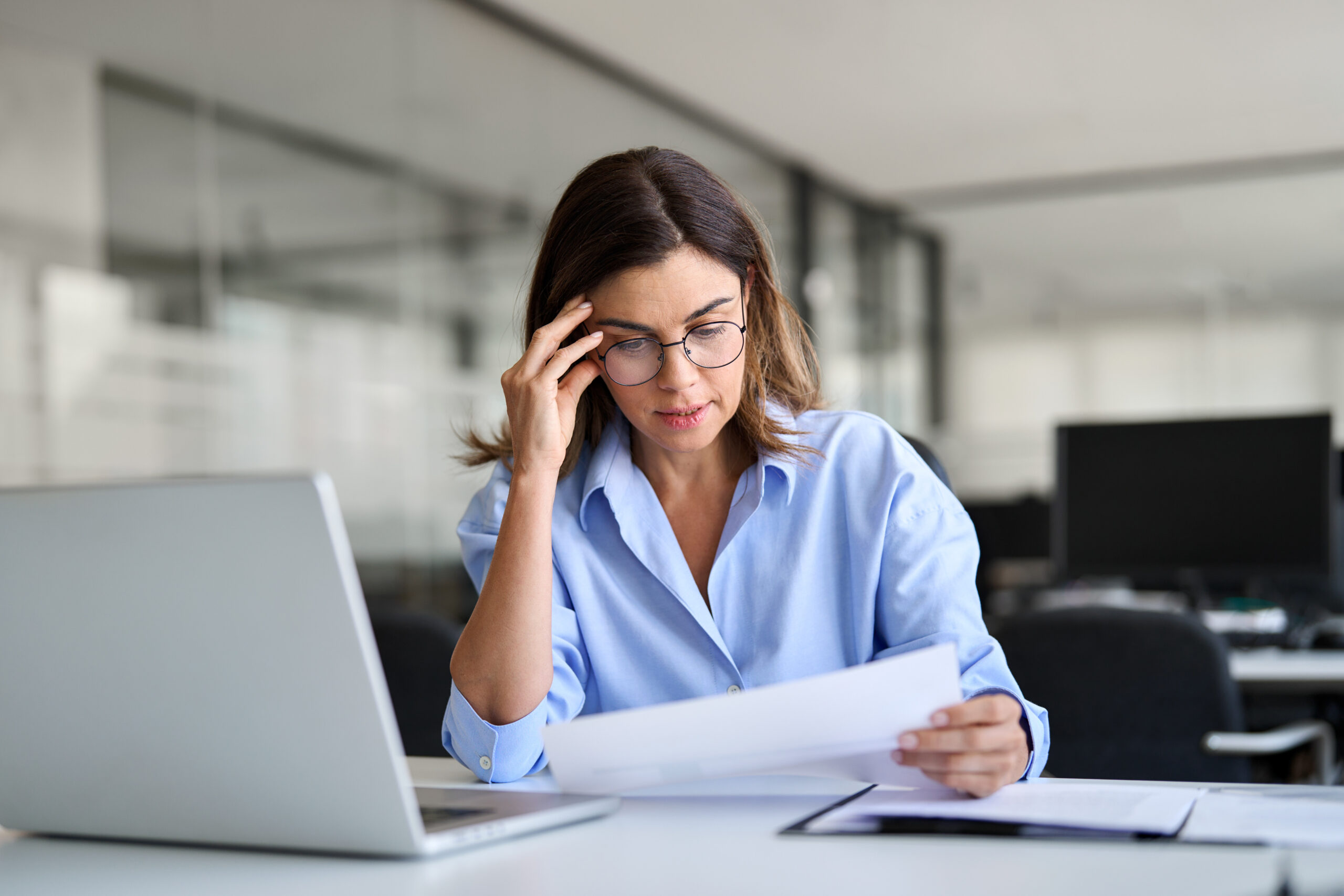 businesswoman reviewing document at desk