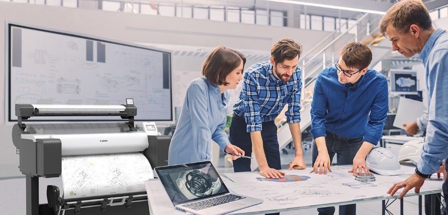 group of people in office with wide format printer