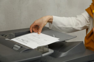 Hand getting paper from printer tray