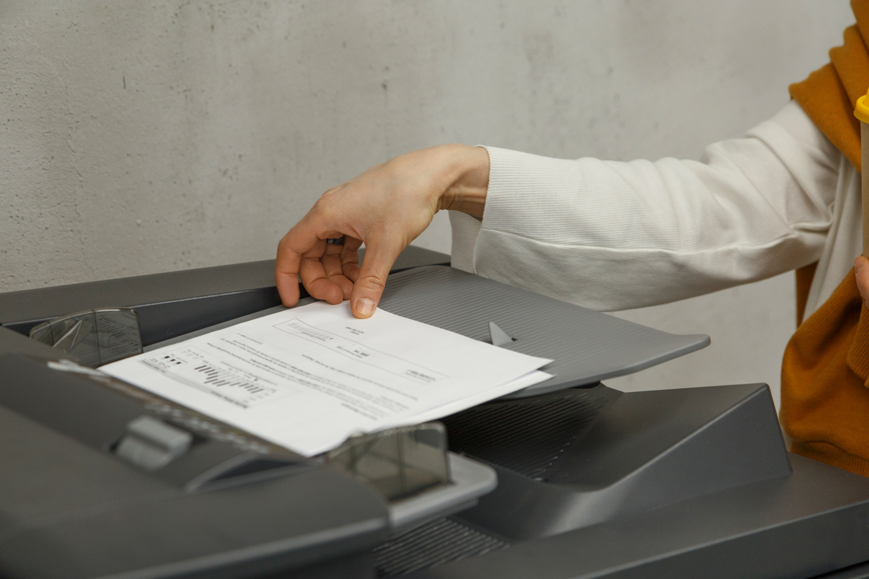 Hand getting paper from printer tray