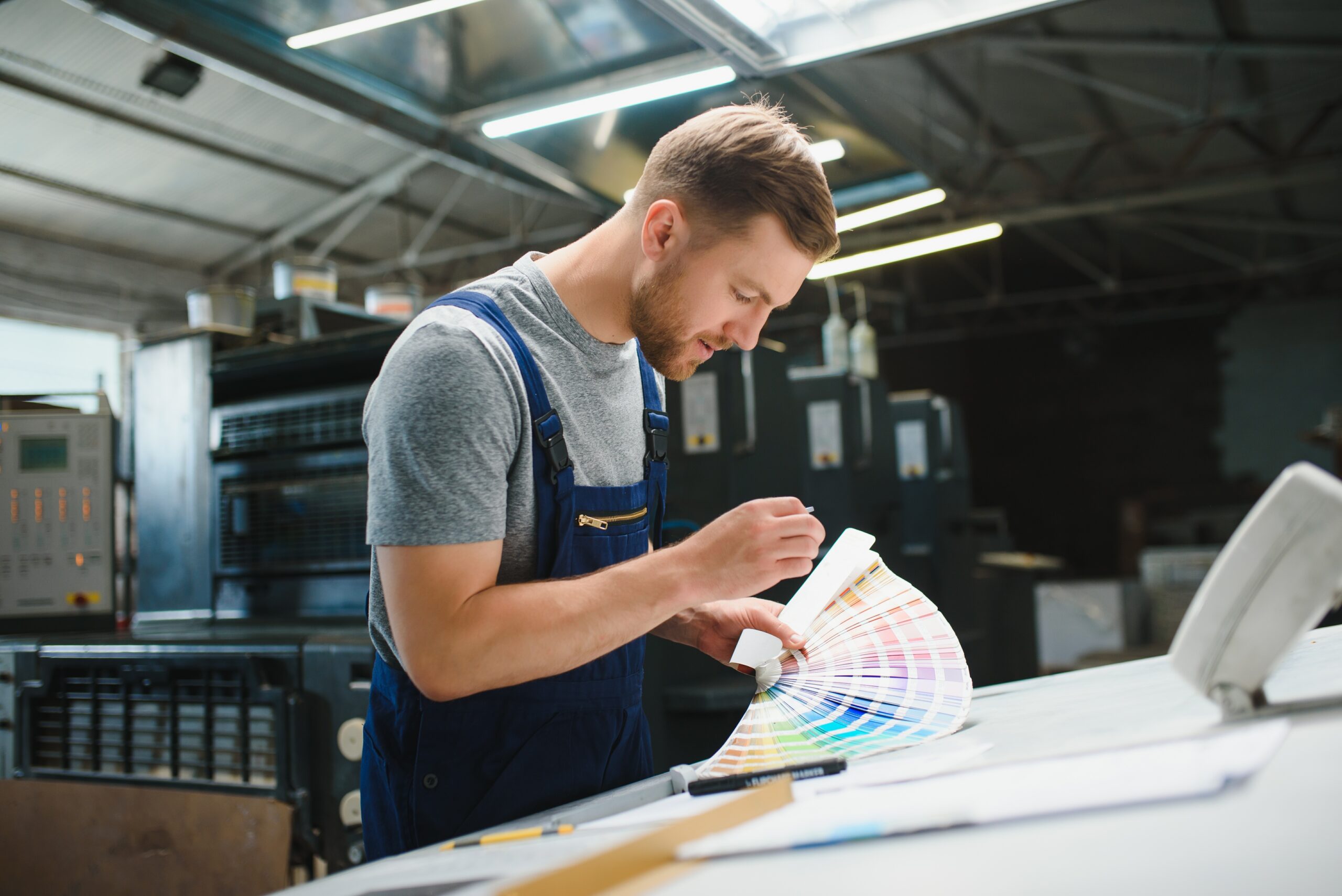 Man in printshop looking at color swatches