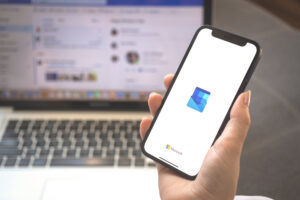 Outlook app logo on mobile phone screen. Woman using Microsoft Outlook application photo