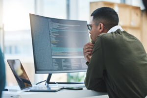 5 Cybersecurity Risks Small Businesses Can't Afford to Ignore - Man looking at computer screen